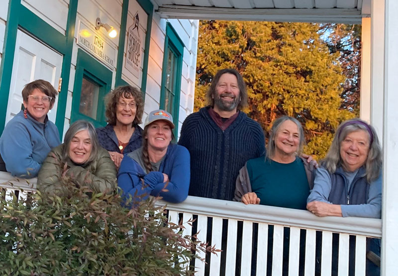 Seven board members on the front porch of the Schoolhouse